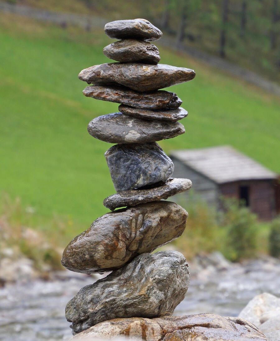 Spiritual grounding and contemplative presence Stacked stones in nature symbolizing balance, presence, and spiritual grounding.